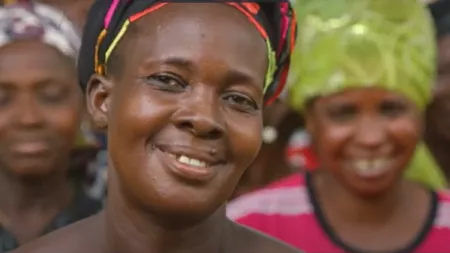 Woman in the foreground smiling and other women in the back